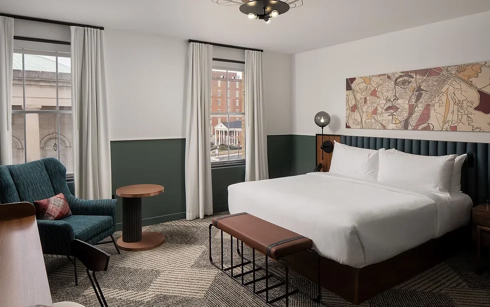 Hotel Forty Five guest room with tall windows, dark green paneling, and a map artwork above the bed