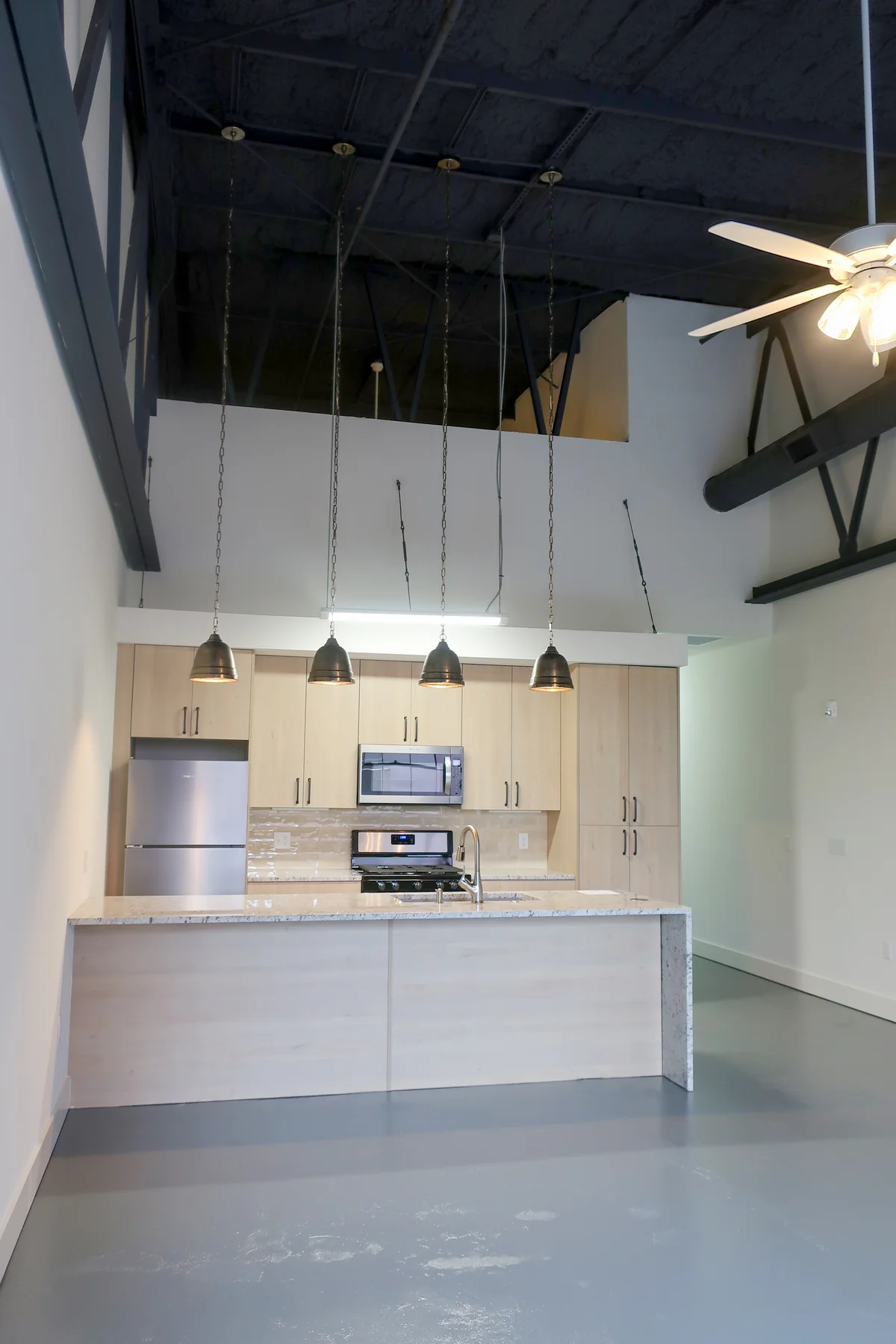 Compact kitchen and tall industrial window at Liberty Lofts