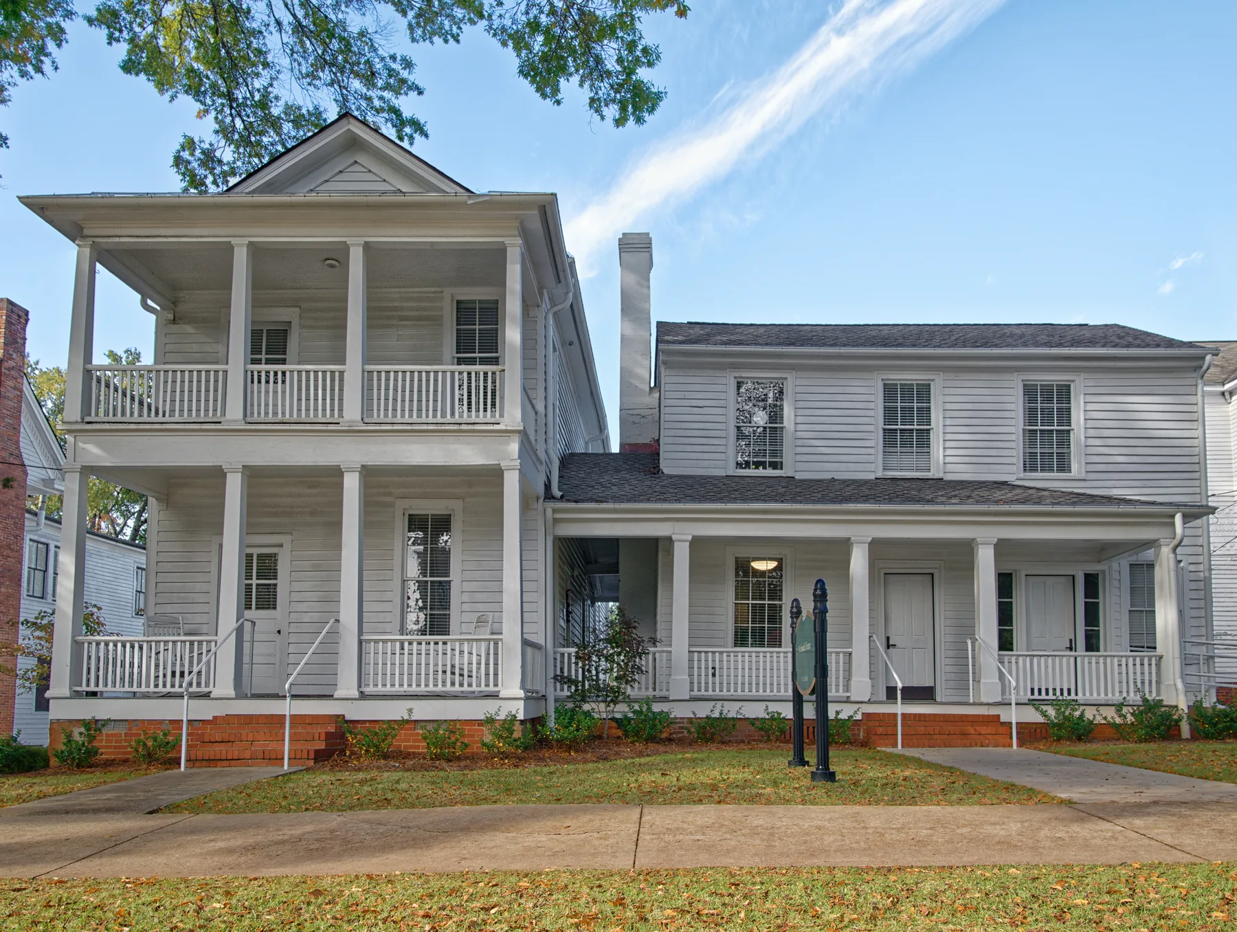 Restored white clapboard McIntosh House with connected porches