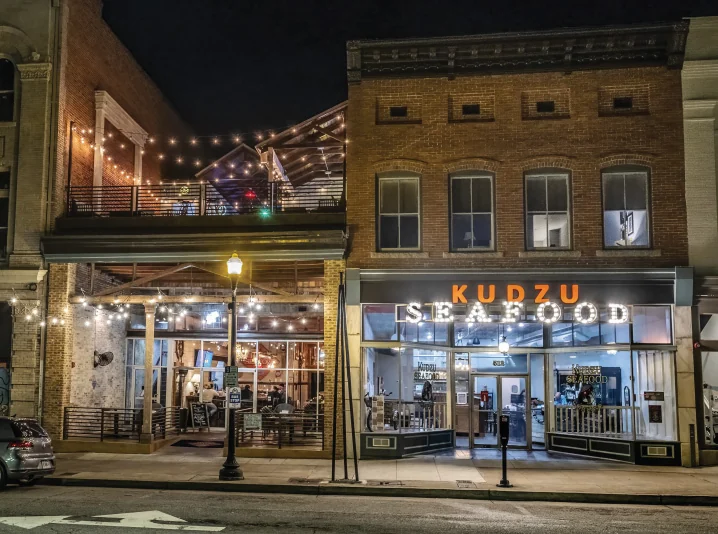 Poptown block of Poplar Street at night, anchored by Kudzu Seafood Company